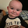 Wade is registered to the contest to win money with this photo: baby, infant, face, smile, eyes, blanket, clothing, shirt, football, indoor, portrait, child, cute, happy, person, cozy, soft, expression, head, young