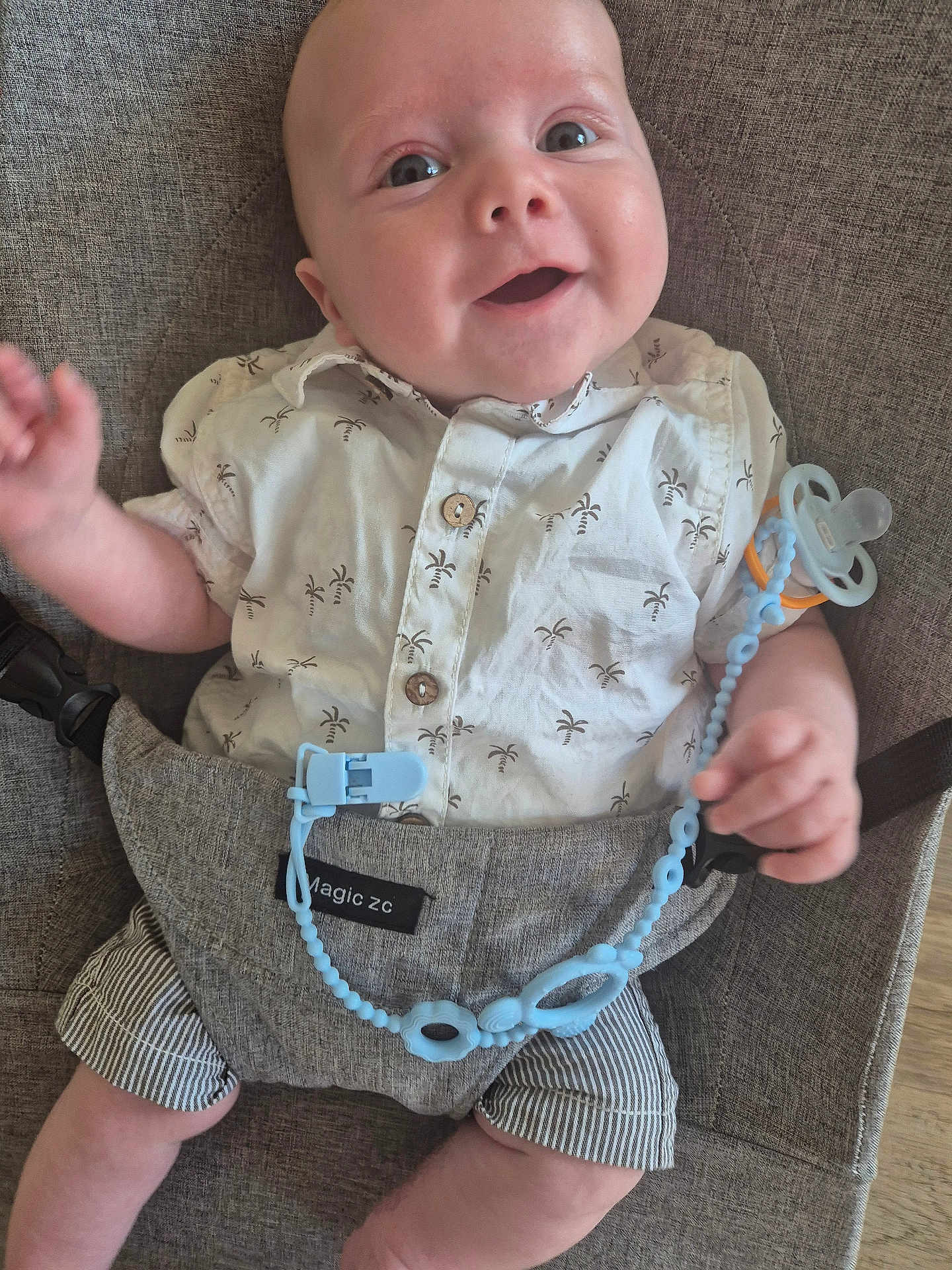 Louka a rejoint le concours — aidez-le/la à gagner de superbes lots ! baby, smiling, infant, face, clothing, shirt, shorts, pacifier, baby_carrier, fabric, seat, happy, cute, child, person, human, indoor, closeup, comfort, accessory