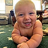 baby, child, infant, smiling, happy, crawling, portrait, face, eyes, tongue, indoor, living_room, carpet, home, furniture, couch, window, daylight, background_person, close_up