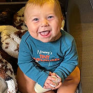 Bowen joined the competition — help win amazing prizes! baby, infant, child, smiling, happy, portrait, sitting, bottle, blanket, plush, toy, blue_shirt, indoors, nursery, seated, bare_feet, close_up, face, cuddly, adorable