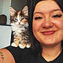 woman, smile, kitten, cat, pet, shoulder, indoor, black_hair, eyelashes, tattoo, glasses, black_shirt, feline, cute, young_adult, portrait, happy, fur, animal, companion