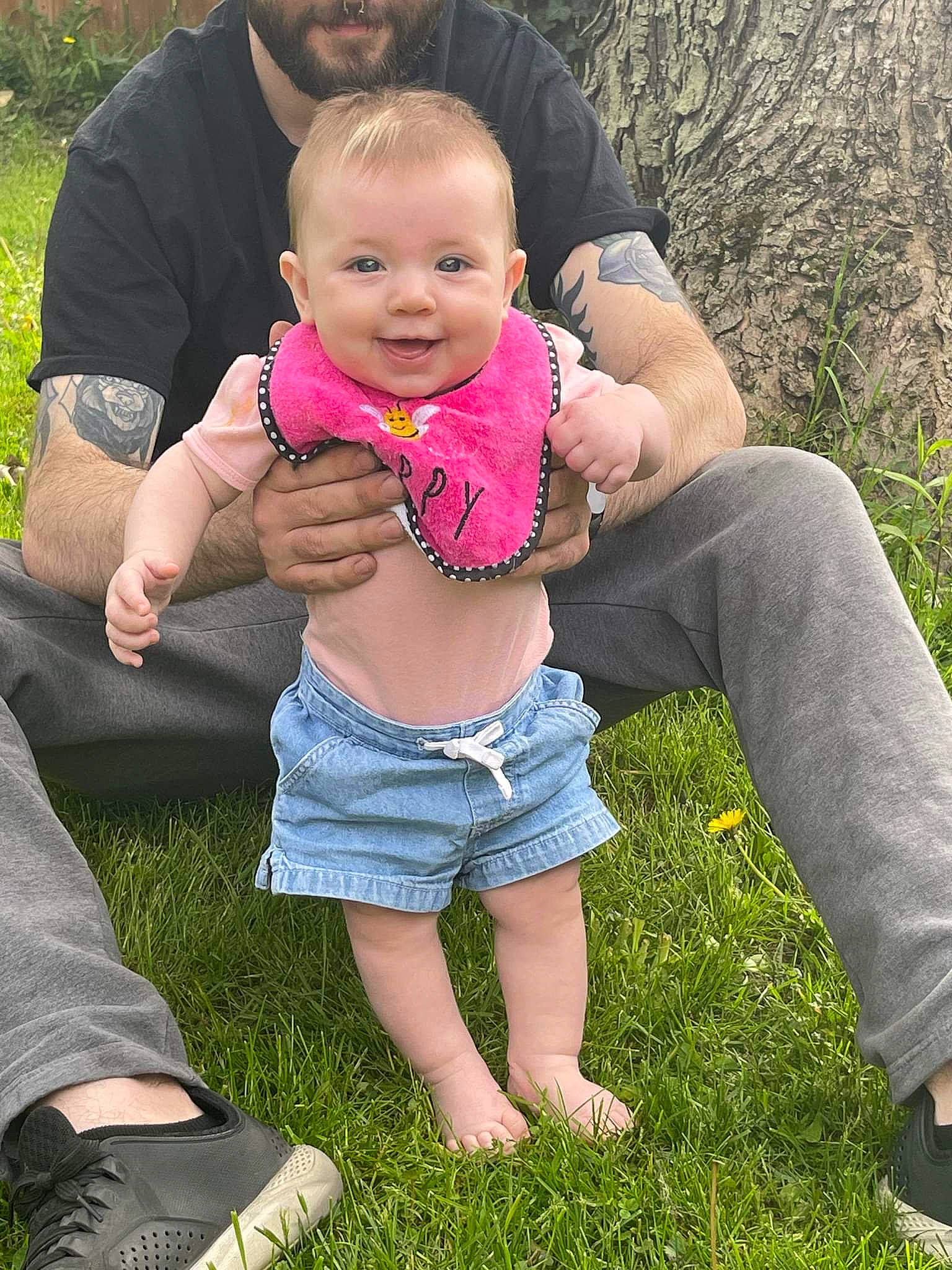Lauren is registered to the contest to win money with this photo: arm, baby, botany, facial_expression, finger, fun, gesture, grass, hand, happy, human, interaction, jeans, joy, leaf, leg, leisure, people_in_nature, person, photograph