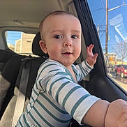 Maison joined the competition — help win amazing prizes! baby, infant, child, car_interior, backseat, car_window, seat, onesie, striped_clothing, hand, face, eyes, portrait, candid, sunlight, reflection, urban, playful, cheek, smile