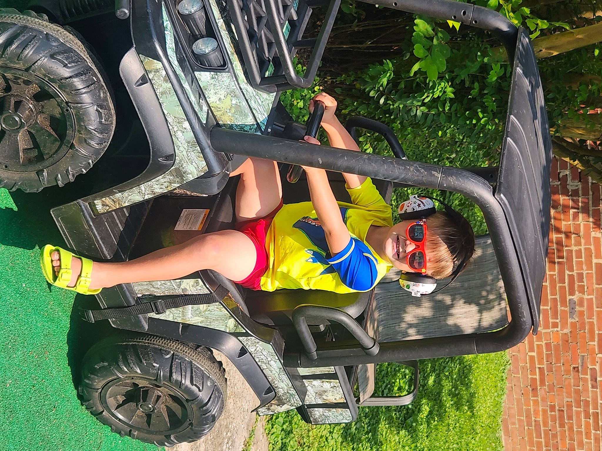 Memphis is registered to the contest to win money with this photo: auto_part, automotive_design, automotive_exterior, automotive_lighting, automotive_tire, automotive_wheel_system, bumper, fender, grass, joy, motor_vehicle, person, plant, recreation, rolling, shorts, sneakers, thigh, tire, vehicle