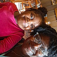 Arianna is registered to the contest to win money with this photo: woman, girl, child, smiling, selfie, glasses, restaurant, wooden_chairs, wooden_tables, indoor, casual, happy, family, people, portrait, seated, african_american, hair, clothing, friendship