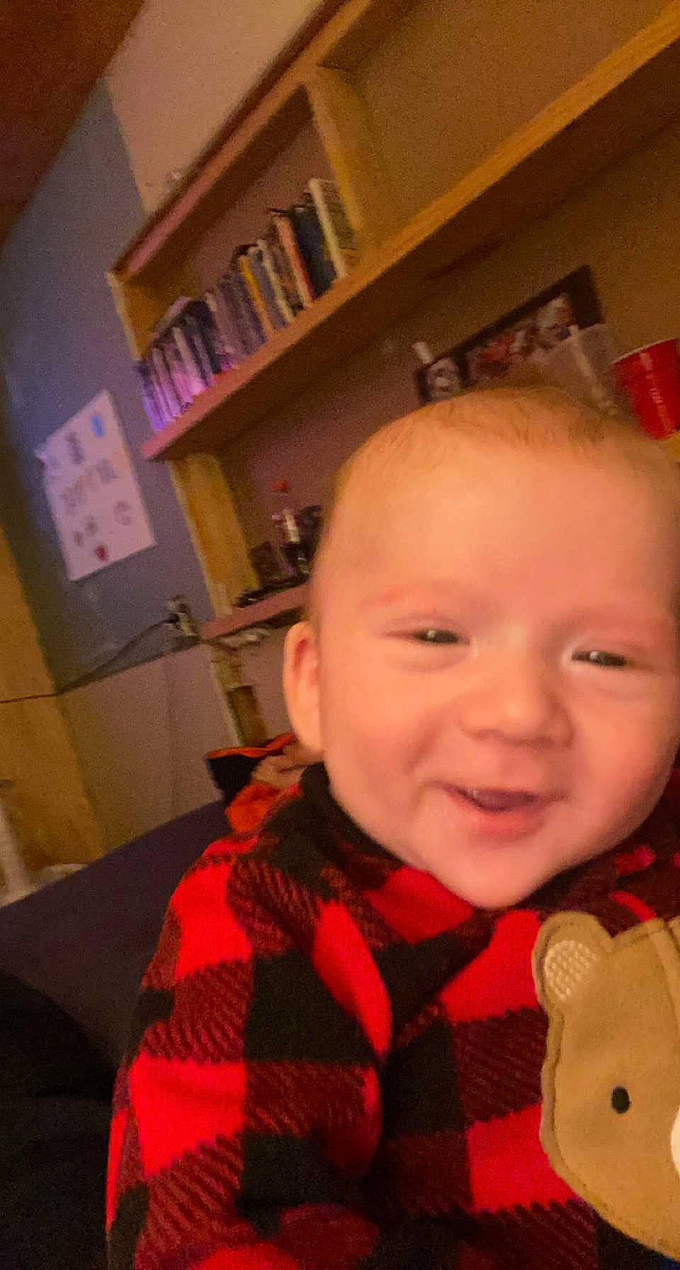 Maverick is registered to the contest to win money with this photo: baby, baby_toddler_clothing, bookcase, cheek, child, chin, ear, eye, fun, happy, human_body, iris, lip, mouth, nose, person, pink, shelf, skin, smile