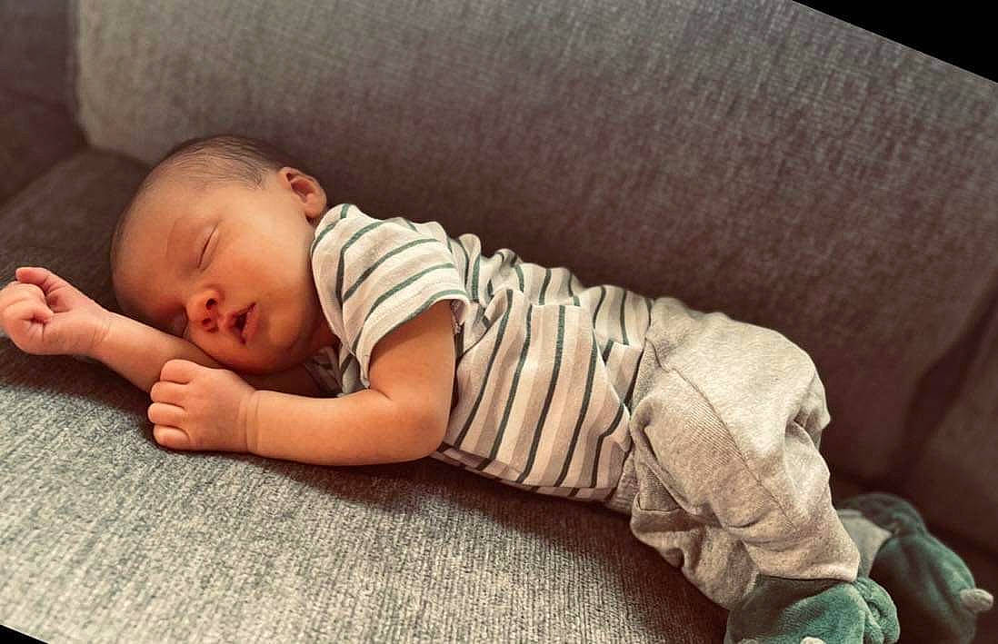 Emmett is registered to the contest to win money with this photo: baby, baby_toddler_clothing, child, comfort, couch, elbow, flooring, human_body, human_leg, knee, linens, person, room, sitting, skin, sleep, sleeve, sock, t_shirt, toddler