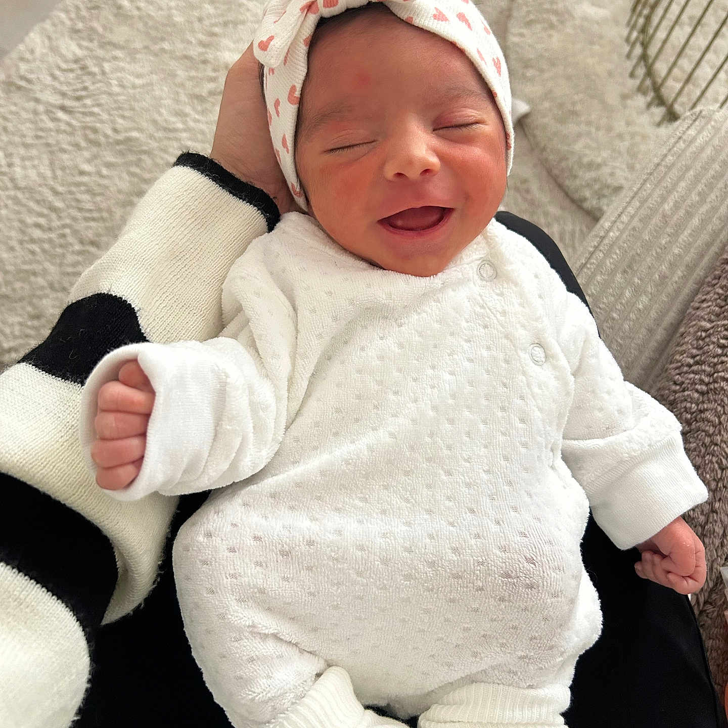 Leïa a rejoint le concours — aidez-le/la à gagner de superbes lots ! adult_hand, baby, bedding, blanket, bow, close_up, cozy, cute, hand, happy, headband, indoors, infant, newborn, onesie, portrait, sleepy, smile, socks, soft_texture