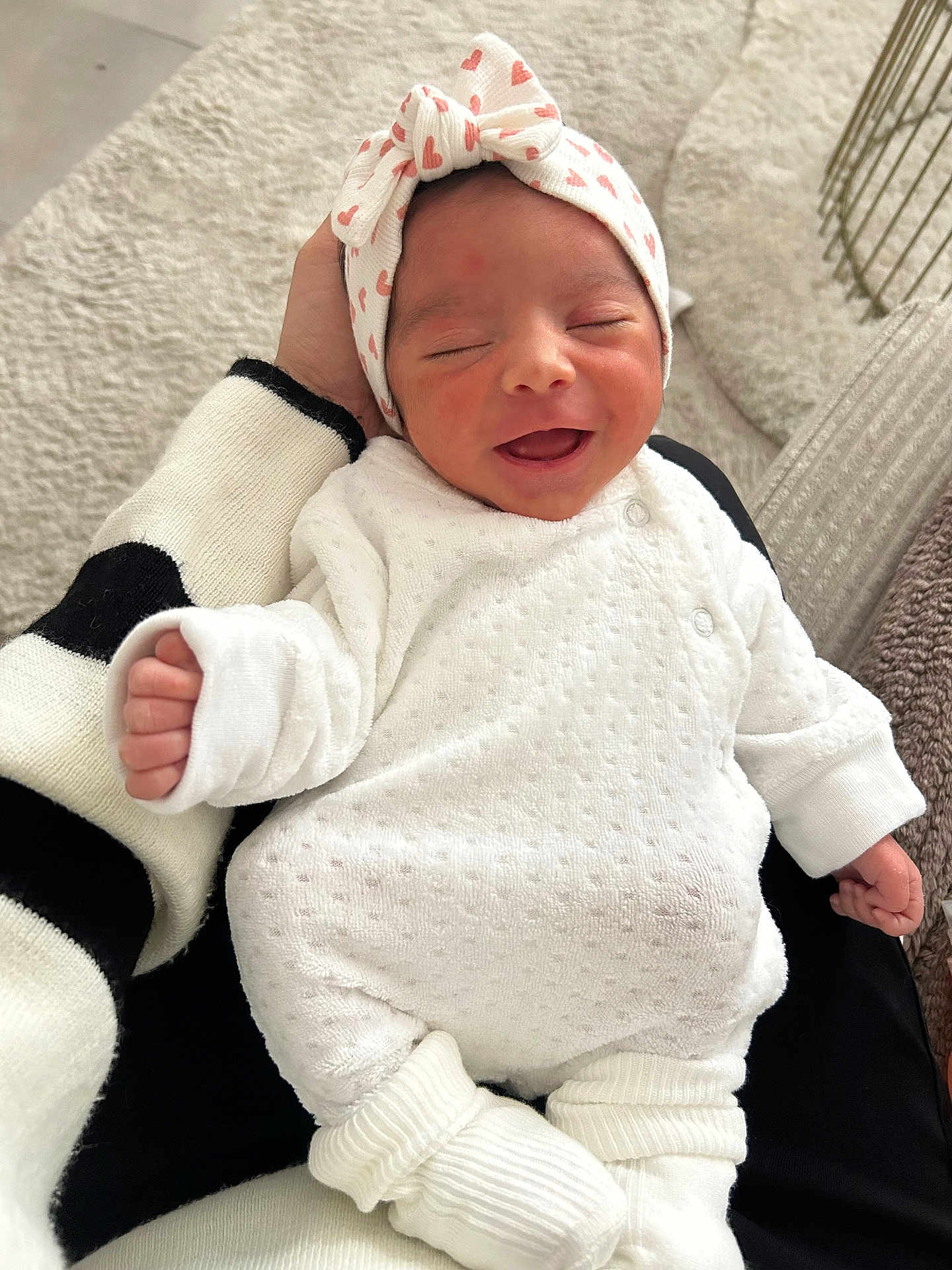 Leïa a rejoint le concours — aidez-le/la à gagner de superbes lots ! baby, newborn, smile, headband, bow, onesie, hand, adult_hand, blanket, bedding, socks, cozy, indoors, portrait, close_up, happy, sleepy, soft_texture, cute, infant