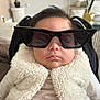 baby, infant, sunglasses, sleeping, cozy, fluffy_vest, fur, portrait, indoors, car_seat, cute, mouth, face, fashion_accessory, eyewear, hair, blanket, clothing, nursery, relaxing