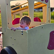 Leonardo is registered to the contest to win money with this photo: baby, car, chair, face, furniture, grass, head, nature, outdoorplayarea, outdoors, park, person, photography, plant, playarea, portrait, slide, toy, transportation, vehicle