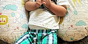 Denym joined the competition — help win amazing prizes! baby, child, infant, smile, cushion, animal_print, tshirt, plaid_shorts, socks, clapping, happy, indoor, cute, lying_down, patterned, young_child, person, fabric, playful, bright