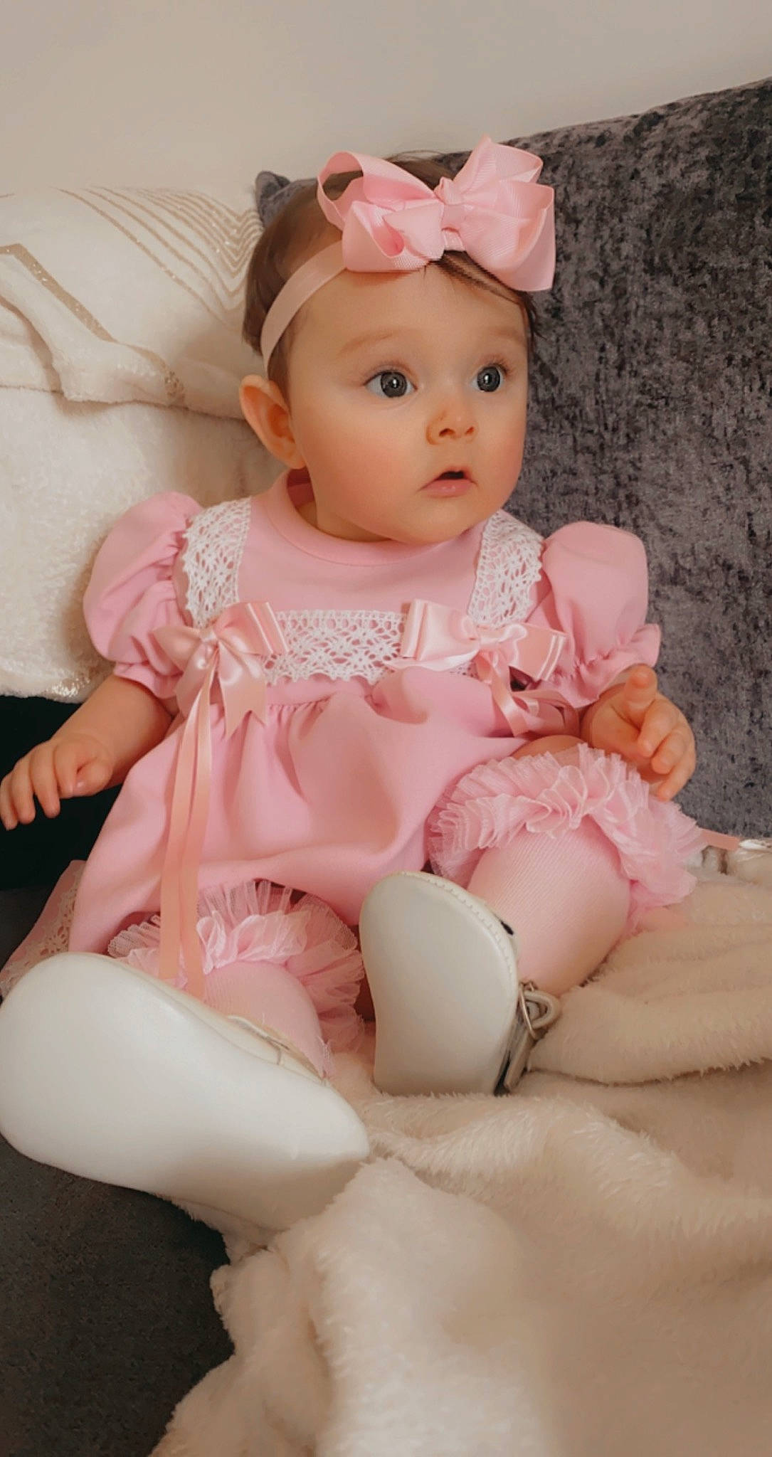 Evelyn joined the competition — help win amazing prizes! baby, baby_toddler_clothing, cheek, child, embellishment, eyelash, fashion_accessory, headband, headwear, human_leg, jewellery, magenta, peach, person, pink, ruffle, sitting, skin, sleeve, sock