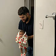Gracelynn joined the competition — help win amazing prizes! baby, clothing, cute, door, floor, footwear, happy, holding, home, indoor, light_switch, man, person, portrait, robe, slippers, smile, strawberry_pattern, towel_rod, wall