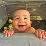 Elijah is registered to the contest to win money with this photo: baby, cheeks, child, closeup, colorful, cute, face, furniture, hands, happy, home, indoor, infant, joyful, person, playpen, portrait, smile, teeth, toys