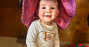 Elijah joined the competition — help win amazing prizes! baby, child, colorful, cute, decor, face, floor_mat, happy, hat, indoor, infant, person, pink, playful, portrait, shorts, sitting, smiling, striped_shirt, toy