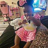 Myaa joined the competition — help win amazing prizes! bed, birthday, chair, child, cute, desk, fingers, floor, footwear, indoor, leopard_print, minnie_mouse_ears, person, pink_clothing, polka_dot, room, sitting, television, thoughtful, toddler