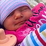 baby, beanie, blanket, bundled, chair, child, close_up, colorful, cute, face, hat, infant, newborn, outdoor, pacifier, pink, portrait, sleepy, smile, striped_clothing