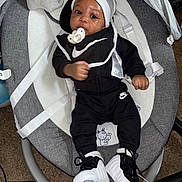Kashmir is registered to the contest to win money with this photo: baby, baby_boy, baby_seat, black_clothing, carpet, carrying_seat, child, closeup, clothing_tag, cute, footwear, hat, indoor, infant, nike, pacifier, portrait, relaxing, sneakers, white_hat