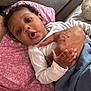 Kashmir is registered to the contest to win money with this photo: baby, bed, blanket, blue, child, comfort, curly_hair, expression, face, hand, holding, indoors, infant, person, pillow, pink, resting, skin, tattoo, white_clothing