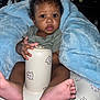 baby, blanket, blue_blanket, bunny_pattern, child, container, cute, face, feet, hand, indoors, infant, person, plush, sitting, soft, toy, wrapping, young, young_child