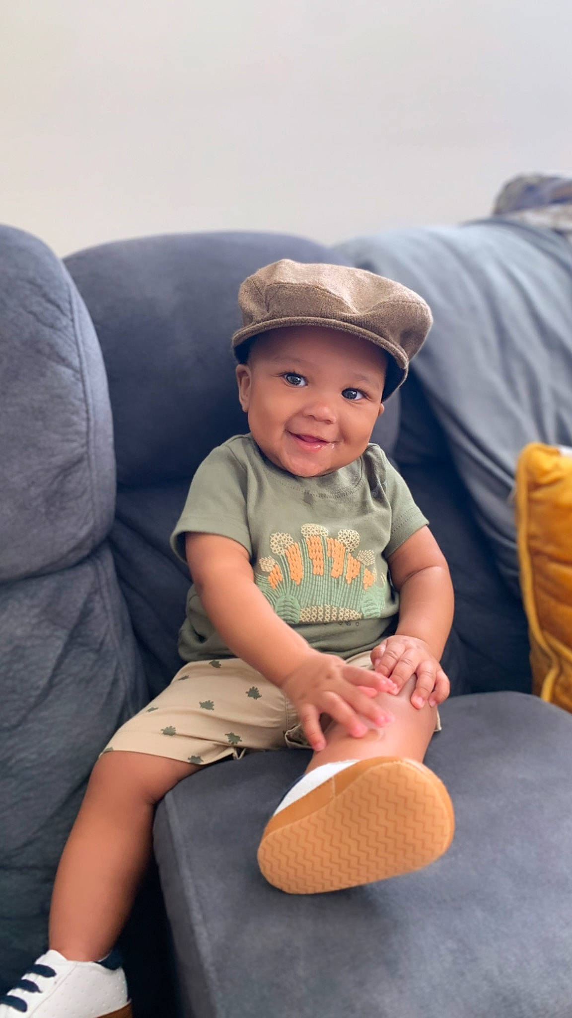 Emilleon is registered to the contest to win money with this photo: baby, baby_toddler_clothing, baseball_cap, cap, chair, child, comfort, fun, happy, hat, headgear, headwear, human_leg, joy, lap, person, shorts, sitting, smile, sun_hat