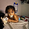 Amir joined the competition — help win amazing prizes! toddler, pacifier, plush_toy, bed, blanket, child, indoor, curly_hair, diaper, person, furniture, wall_chart, colorful, cute, baby, portrait, resting, looking_away, soft_toy, cozy