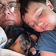 Pepper joined the competition — help win amazing prizes! person, child, dog, sleeping, glasses, blanket, couch, closeup, rest, family, nap, indoor, comfort, affection, cozy, portrait, tired, relax, casual_clothing, bond