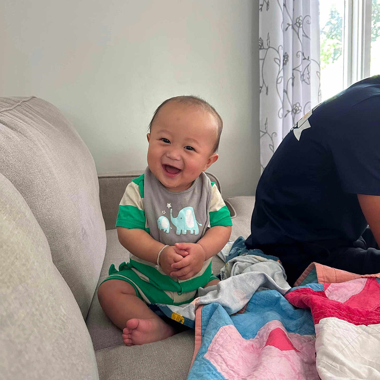 Quincy is registered to the contest to win money with this photo: adult, baby, babylaughing, blanket, clothing, couch, cushion, face, furniture, happy, head, homedecor, laughing, male, man, person, photography, portrait, sitting, t_shirt