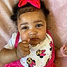 baby, child, infant, pink_bow, bib, minnie_mouse, thumbs_up, close_up, cute, portrait, soft_blanket, clothing, expression, face, hand, person, indoor, adorable, young_child, fashion