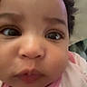 Sa'Vanii is registered to the contest to win money with this photo: baby, face, close_up, eyes, nose, mouth, skin, expression, infant, child, curly_hair, portrait, cute, pink_clothing, indoor, young, human, person, cheeks, curiosity