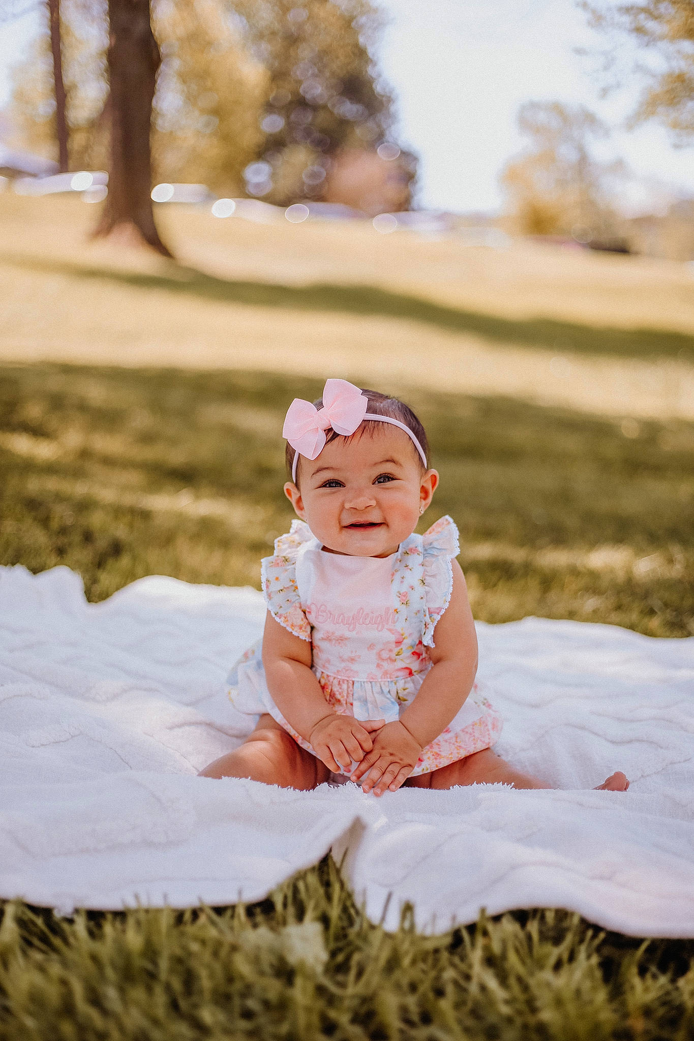 Brayleigh joined the competition — help win amazing prizes! baby, baby_toddler_clothing, dress, event, flash_photography, fun, grass, happy, hat, headpiece, headwear, joy, peach, people_in_nature, person, photograph, plant, sitting, sky, smile