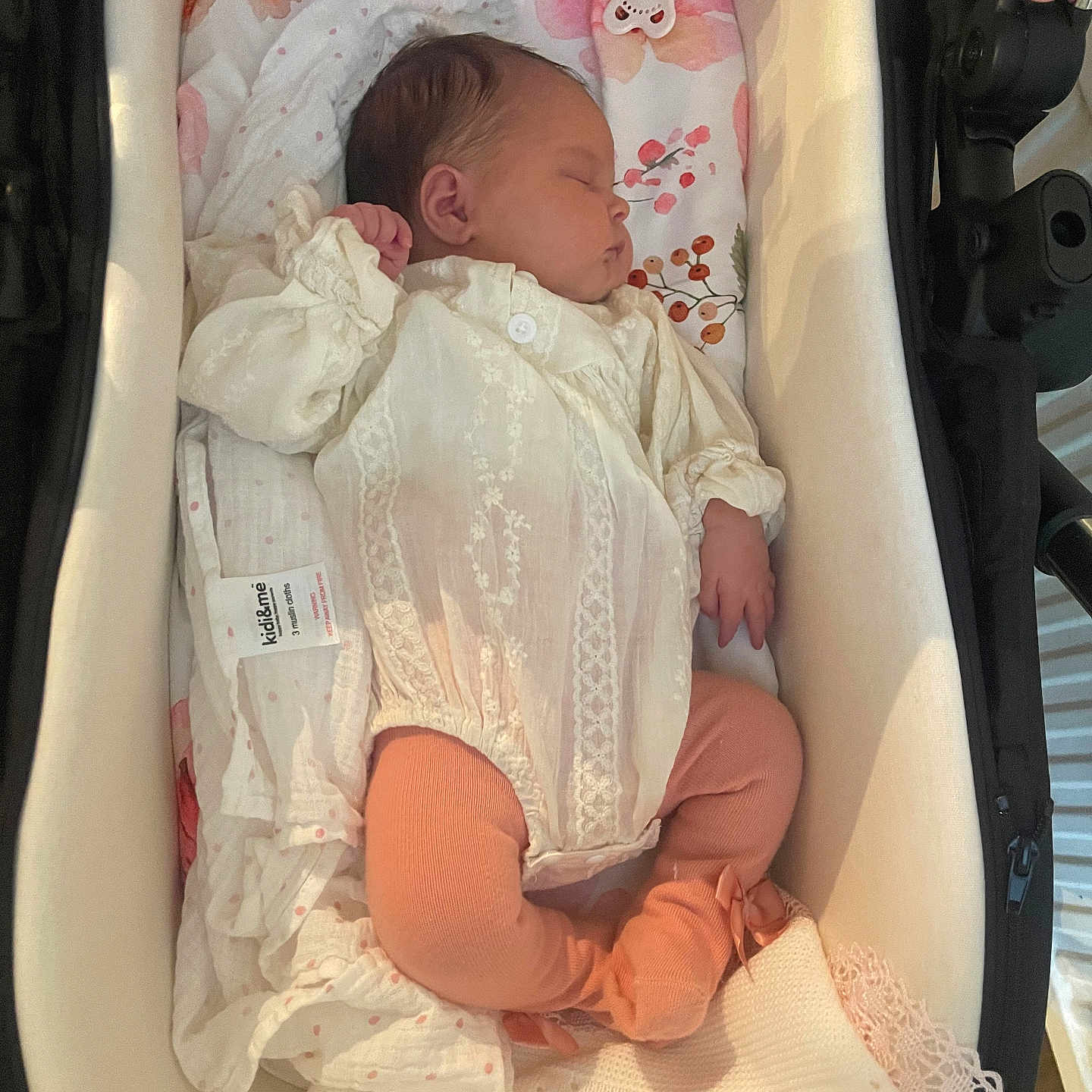 Norah is registered to the contest to win money with this photo: baby, bassinet, blanket, child, clothing, cozy, cute, floral, indoors, infant, newborn, pacifier, peaceful, pink, portrait, resting, sleeping, soft, tights, white