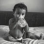 Roy a rejoint le concours — aidez-le/la à gagner de superbes lots ! baby, bottle, diaper, bed, curly_hair, black_and_white, child, infant, cute, sitting, indoors, portrait, soft_lighting, curious, young_child, bedding, face, hands, legs, foot