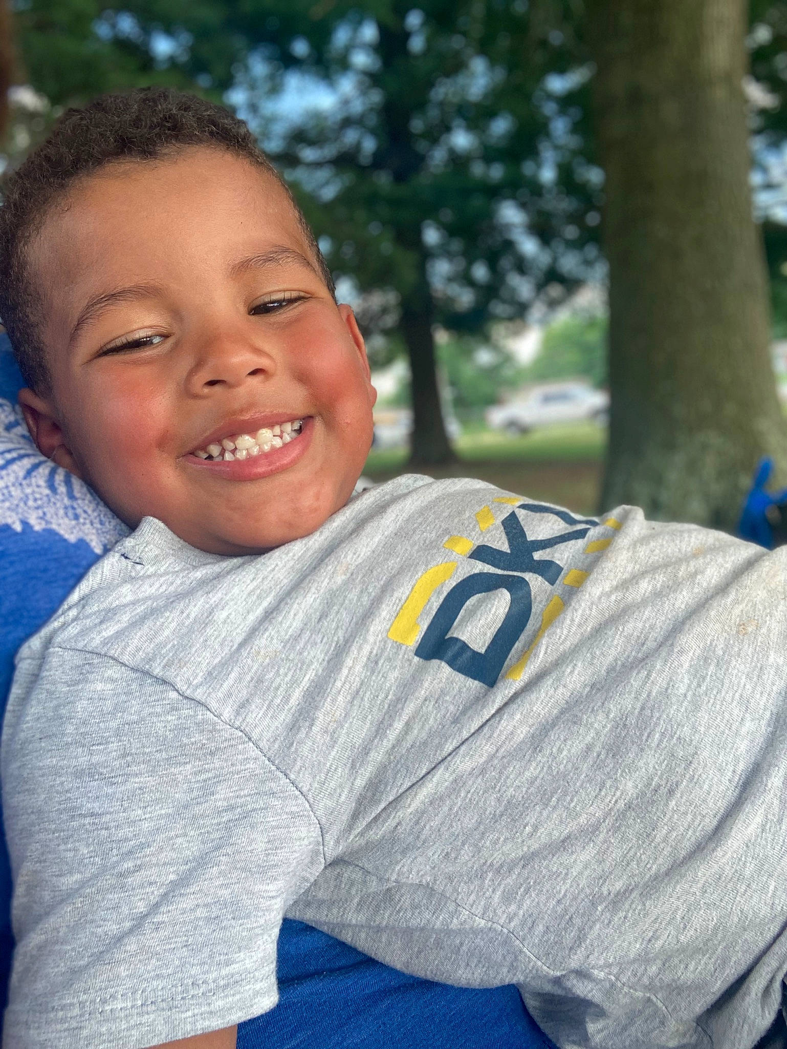 Tyson is registered to the contest to win money with this photo: child, competition_event, electric_blue, fun, grass, hair, happy, head, jersey, joy, leisure, neck, person, player, recreation, shoulder, sitting, smile, sportswear, t_shirt