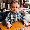 élio a rejoint le concours — aidez-le/la à gagner de superbes lots ! toddler, child, high_chair, restaurant, table, wooden_tray, curly_hair, checkered_shirt, jeans, hands, face, indoor, dining_room, people, background, glasses, chairs, table_setting, portrait, casual_clothing