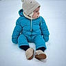 child, toddler, snow, winter_clothing, snowsuit, hat, pacifier, outdoor, cold_weather, boots, sitting, blue, beige, cute, winter, play, baby, frozen, snowy_background, warm_clothes
