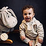 élio a rejoint le concours — aidez-le/la à gagner de superbes lots ! baby, child, curly_hair, smiling, barefoot, hoodie, plush_toy, donkey, rocking_toy, indoor, portrait, floor, cute, infant, sitting, happy, soft_lighting, studio, young_child, cozy