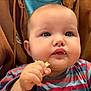 baby, child, face, blue_eyes, cheeks, hand, food, snack, striped_shirt, clothing, person, hoodie, brown_clothing, indoor, portrait, closeup, munching, cute, young_child, eating