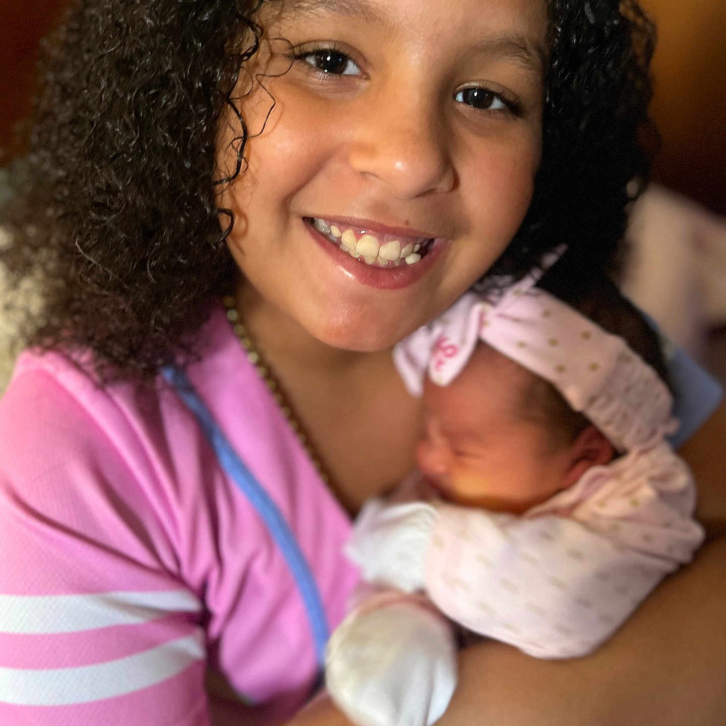 Jolisa is registered to the contest to win money with this photo: arm, baby, baby_mitten, child, curly_hair, cute, face, family, happy, headband, hug, indoor, love, newborn, pink_clothing, portrait, sibling, skin, smile, toddler