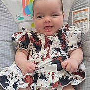Lainey joined the competition — help win amazing prizes! baby, bouncer, child, chubby_cheeks, cute, dress, face, hands, indoors, infant, legs, patterned_dress, playful, portrait, rug, seat, smiling, tongue_out, warning_label, wood_floor