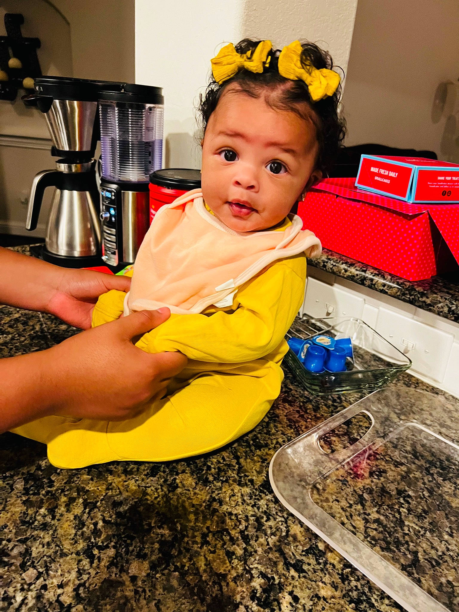 Hendrix is registered to the contest to win money with this photo: baby, baby_toddler_clothing, chair, child, coffeemaker, fashion_accessory, flooring, food_processor, fun, happy, headband, home_appliance, kettle, kitchen_appliance, people, person, play, sitting, soil, surprise