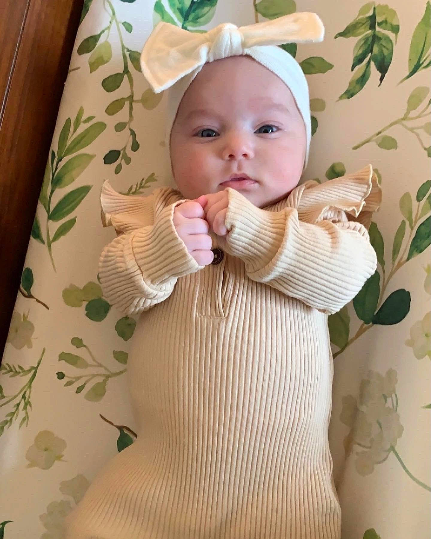 Effie is registered to the contest to win money with this photo: arm, baby, baby_toddler_clothing, cap, cheek, clothing, dress, eyelash, facial_expression, finger, hand, head, headgear, headwear, lip, person, pink, product, skin, sleeve