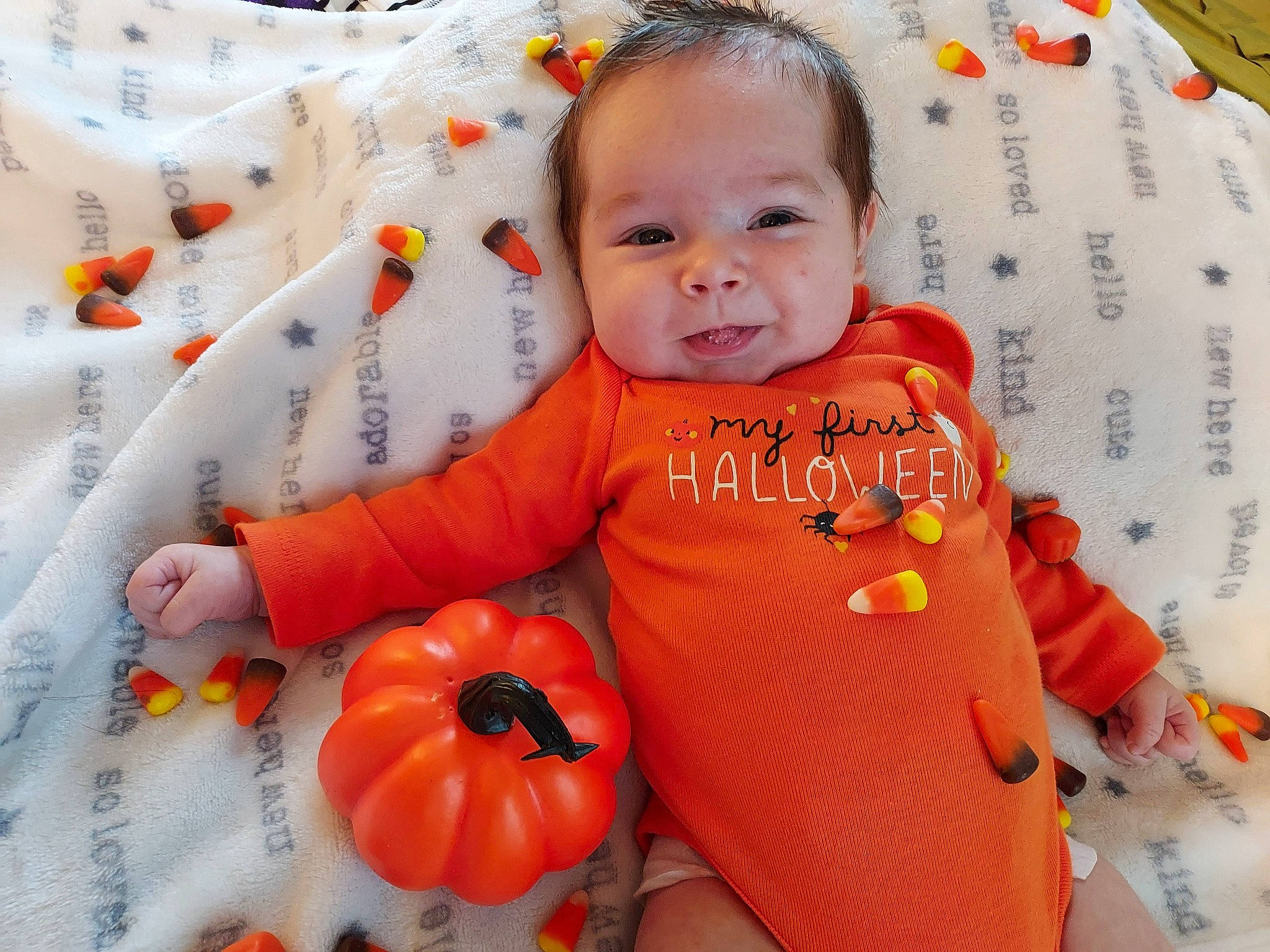 Layne is registered to the contest to win money with this photo: baby, baby_toddler_clothing, calabaza, child, eye, happy, head, iris, natural_foods, orange, pattern, person, pumpkin, sitting, skin, sleeve, smile, t_shirt, toddler, vegetable
