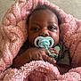 Katara is registered to the contest to win money with this photo: baby, pacifier, blanket, pink, child, infant, hand, face, curly_hair, cute, soft, comfort, wrapped, resting, indoors, young, portrait, skin, clothing, relax