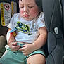 toddler, child, sleeping, car_seat, pacifier, shorts, tshirt, dinosaur_print, rosy_cheeks, hands, natural_light, indoors, seatbelt, car_interior, cute, peaceful, young_child, portrait, clothing, baby
