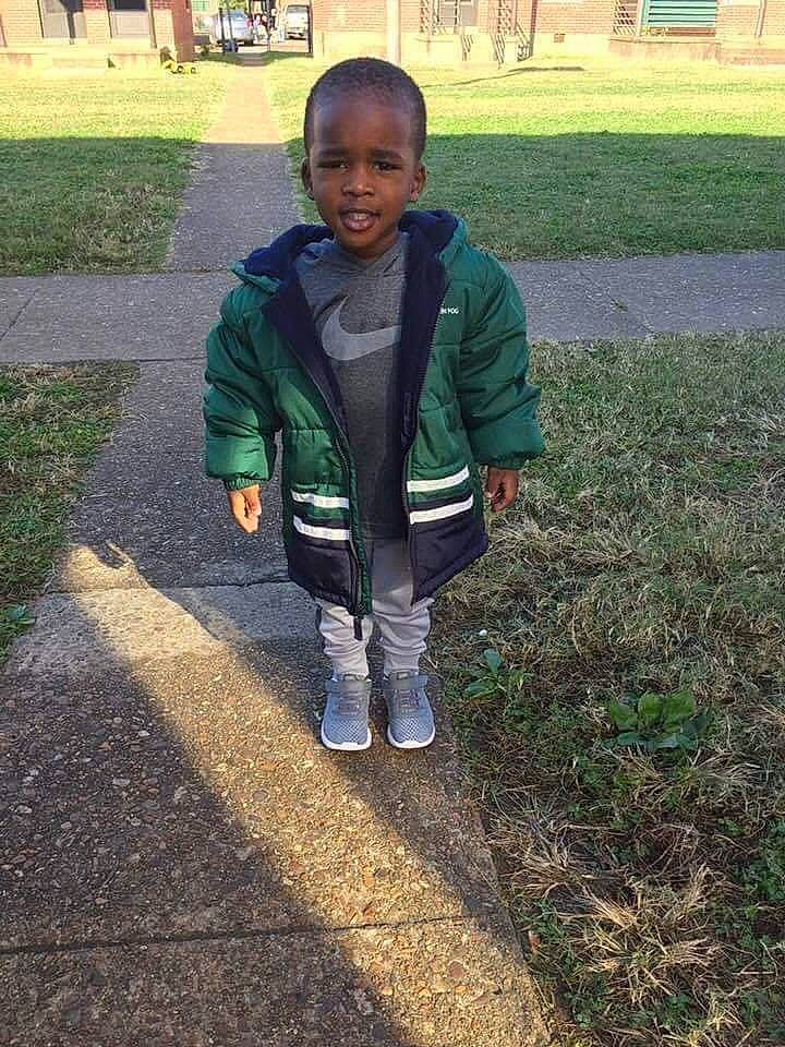 Kamarriun is registered to the contest to win money with this photo: child, cool, grass, head, jacket, jeans, lawn, leaf, outerwear, person, plant, shoe, smile, soil, standing, toddler, tree