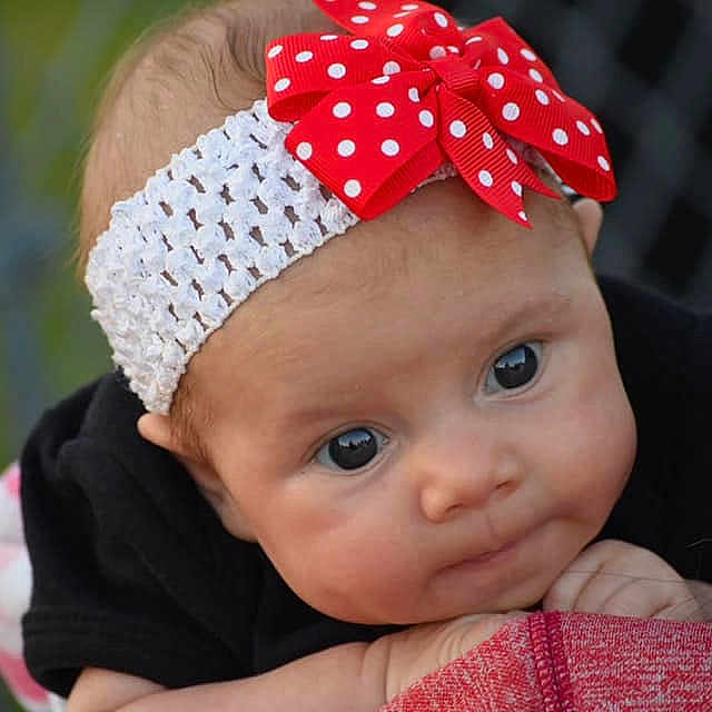 Whitley joined the competition — help win amazing prizes! baby, beanie, bonnet, child, clothing, fashion_accessory, hair_accessory, headband, headgear, person, red, toddler