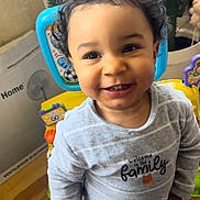 Evan a rejoint le concours — aidez-le/la à gagner de superbes lots ! baby, cactus, child, curly_hair, cute, decor, face, furniture, happy, home, indoor, pajamas, person, plant, portrait, smiling, standing, toddler, toy, wooden_floor