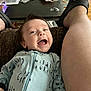 baby, infant, smiling, happy, onesie, clothing, person, face, leg, footwear, sandal, indoor, table, snacks, plastic_bag, hair, skin, joy, expression, couch